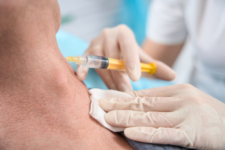 Close-up shot of medic in gloves injecting a platelet rich plasma into person neck with the help of syringe